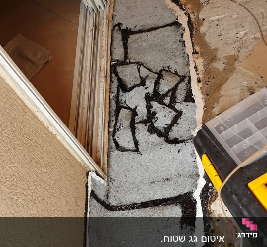 איטום רצפה עם חומר שחור ולבן ליד דלת הזזה